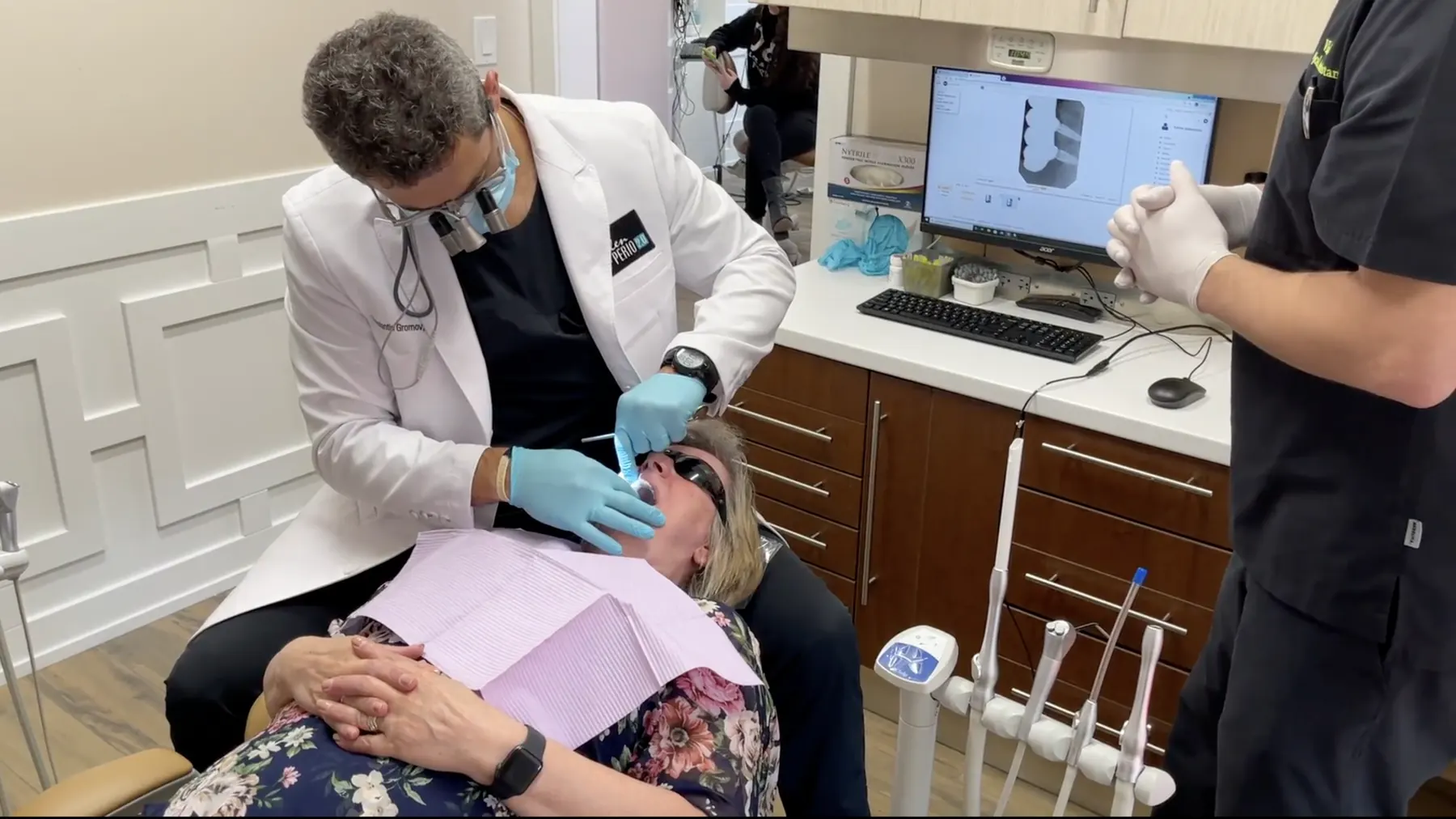Two-clinician surgical team placing a dental implant